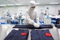 北京冬季五輪の関係者が着用する防護服を作る作業員。中国・山東省浜州市で（2022年1月27日撮影）。(c)AFP