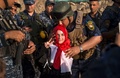 イラク・モスルの旧市街で、政府によるモスル解放宣言を祝い少女にキスするイラク連邦警察部隊の隊員（2017年7月9日撮影）。(c)AFP/FADEL SENNA