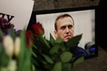 北極圏の刑務所で死亡したロシアの反体制派指導者アレクセイ・ナワリヌイ氏の写真に手向けられた花。英ロンドンにあるロシア大使館の外で（2024年2月16日撮影）。(c)Daniel LEAL / AFP