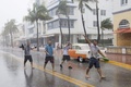 米フロリダ州マイアミビーチで、ハリケーン「イルマ」に伴う風と雨の中、通りを歩く人たち（2017年9月9日撮影）。(c)AFP/SAUL LOEB