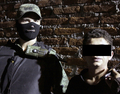 メキシコ・モレロス（Morelos）州クエルナバカ（Cuernavaca）で、同国軍兵士に連行された、麻薬密売組織の殺し屋の疑いのあるエドガー・ヒメネス（Edgar Jimenez）容疑者（右、2010年12月2日撮影）。(c)AFP/David Monroy