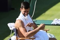 男子テニスのエキシビション大会、ジョルジオ・アルマーニ・テニスクラシックのフェリックス・オジェ・アリアシム戦で、観客の声援に対して上腕を指し示すノバク・ジョコビッチ（2022年6月22日撮影）。(c)Adrian DENNIS/ AFP