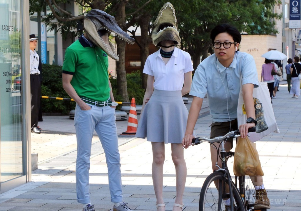 都内街角にワニのマスク着用の人々