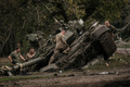 ウクライナ・ハルキウ市郊外に放置されたロシア軍の戦車T90Aを調べるウクライナ兵（2022年9月30日撮影）。(c)Yasuyoshi CHIBA / AFP