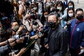 香港国家安全維持法（国安法）の「国家政権転覆共謀罪」で起訴され、警察署の前で記者会見する戴耀廷（ベニー・タイ）氏（中央、2021年2月28日撮影）。(c)ISAAC LAWRENCE / AFP