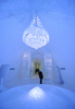 スウェーデン北部ユッカスヤルビ（Jukkasjaervi）の「アイスホテル（Icehotel）」の廊下にある、氷でできたシャンデリアを眺める宿泊客（2009年1月8日撮影）。(c)AFP/OLIVIER MORIN