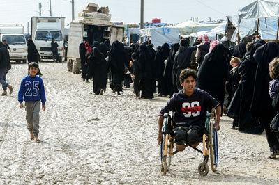 「足を失った男性、微笑む少年、並ぶ女性たち」