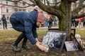 ラトビアの首都リガのロシア大使館前でアレクセイ・ナワリヌイ氏の写真の前にろうそくを置く女性（2024年3月17日撮影）。(c)GINTS IVUSKANS / AFP