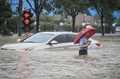 中国・河南省鄭州市で、冠水した道路を歩く人（2021年7月20日撮影）。(c)STR / AFP