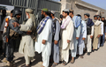 アフガニスタン南部カンダハル（Kandahar）の投票所で、投票に訪れた有権者の検査をする警官（左、2009年8月20日撮影）。(c)AFP/BANARAS KHAN