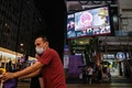 香港中心部にある、交差点の大画面と歩行者（2020年5月21日撮影）。(c)Anthony WALLACE / AFP
