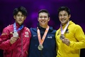 第51回世界体操競技選手権、男子種目別鉄棒。表彰式に臨む（左から）2位に入った橋本大輝、優勝した米国のブロディ・マローン、3位に入ったブラジルのアルトゥール・オヤカワ・マリアーノ（2022年11月6日撮影）。(c)Paul ELLIS / AFP