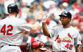 米大リーグ（MLB）で15日、アフリカ系米国人初の大リーガーとして活躍した故ジャッキー・ロビンソン（%%Jackie Robinson%%）氏の栄誉をたたえるジャッキー・ロビンソンデーを迎え、全試合で全選手、全コーチ陣、全審判員が同氏の永久欠番である背番号「42」を着用して試合に臨んだ。写真はアリゾナ・ダイヤモンドバックス（%%Arizona Diamondbacks%%）戦で本塁を踏み、ジョー・サーストン（%%Joe Thurston%%、右）とハイタッチを交わすセントルイス・カージナルス（%%St. Louis Cardinals%%）のクリス・ダンカン（%%Chris Duncan%%）。（2009年4月15日撮影）（c）AFP/Getty Images/Christian Petersen