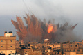 イスラエル軍に空爆されたパレスチナ自治区ガザ地区（Gaza Strip）南部のラファ（Rafah）で、イスラエル軍の空爆を受けた建物から立ち上る炎と煙（2014年7月11日撮影）。(c)AFP/SAID KHATIB
