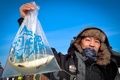 米ミネソタ州ブレーナードにあるガル湖で行われた氷上釣り大会で、釣った魚を見せる参加者（2022年1月29日撮影）。(c)Kerem Yucel / AFP