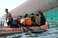フィリピン中部ロンブロン（Romblon）州シブヤン島（Sibuyan Island）沖で転覆した大型フェリー「プリンセス・オブ・ザ・スターズ（Princess of the Stars）」の船体と、捜索にあたるフィリピン沿岸警備隊と空軍による潜水救助チーム（2008年6月23日撮影）。(c)AFP/ROMEO GACAD