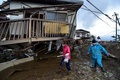 台風19号（アジア名：ハギビス）の影響を受けた長野県で、洪水の被害に見舞われた住宅の脇を歩く住民ら（2019年10月15日撮影）。(c)Kazuhiro NOGI / AFP