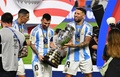 サッカーコパ・アメリカ決勝、アルゼンチン対コロンビア。優勝トロフィーを手にするアルゼンチンのリオネル・メッシ（中央）とニコラス・オタメンディ（右、2024年7月14日撮影）。(c)Chandan Khanna/ AFP