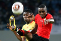 サッカーアフリカ・ネイションズカップ（アフリカ選手権、%%African Nations Cup 2010%%）グループリーグC、モザンビーク対ベナン。試合は2-2の引き分けに終わった。写真はボールを競るベナンのフェリシアン・シングボ（%%Felicien Singbo%%、左）とモザンビークの%%Elias Pelembe%%。（2010年1月12日撮影）(c)AFP/KHALED DESOUKI