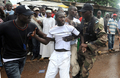 ギニアの首都コナクリ（Conakry）で行われた軍事政権に対する抗議集会の会場となったスタジアム前で、参加者を拘束する警官（2009年9月28日撮影）。(c)AFP/SEYLLOU