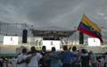 コロンビア西部エルディアマンテにある「コロンビア革命軍（FARC）」のキャンプで、大画面で放映された和平協定調印式典の様子を見守ったFARCメンバーら（2016年9月26日撮影）。(c)AFP/RAUL ARBOLEDA