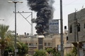 パレスチナ自治区ガザ地区（Gaza Strip）南部のハンユニス（Khan Yunis）東部で、イスラエル軍の攻撃を受け煙が立ち上る建物（2014年7月23日撮影）。(c)AFP/SAID KHATIB