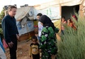 レバノン東部ベカー高原にあるシリア難民キャンプで、難民の家族が住むテントを訪れた英国のデービッド・キャメロン首相（左、2015年9月14日撮影）。(c)AFP/STEFAN ROUSSEAU