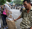 2007年8月24日、ハノイ（Hanoi）市内の繁華街で、お盆に燃やす紙製の自転車を袋詰めする販売員（左）と買い物客。(c)AFP/HOANG DINH Nam
