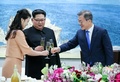 韓国と北朝鮮の軍事境界線上の板門店で開かれた南北首脳会談の晩さん会で、韓国の文在寅大統領（右）と乾杯する北朝鮮の金正恩朝鮮労働党委員長（中央）と李雪主夫人（左、2018年4月27日撮影）。(c)AFP PHOTO / Korea Summit Press Pool