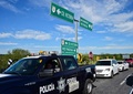 メキシコ北東部タマウリパス州で、ギャングが横行する高速道路101号線を連邦警察のパトカーに先導されて走る一般車両（2015年12月16日撮影）。(c)AFP/RONALDO SCHEMIDT