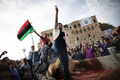 リビアの首都トリポリ（Tripoli）の「殉教者広場（Martyr&apos;s Square）」で、いけにえのラクダ2頭を捧げて全土解放を祝う男性（2011年10月23日撮影）。(c)AFP/MARCO LONGARI