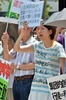 都内・国会議事堂そばで行われた安倍政権への抗議デモで、プラカードを掲げスローガンを唱えるデモ参加者（2014年7月14日撮影）。(c)AFP/Yoshikazu TSUNO