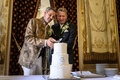 スイス・ジュネーブで行われた結婚式で、ケーキに入刀するダニエルさん（右）とグザビエさん（2022年7月1日撮影）。(c)Fabrice COFFRINI / AFP