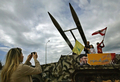 写真は18日、ティールのQasmiyeh地区で、立てられた模型を背景に写真を撮る家族。(c)AFP/MAHMOUD ZAYAT