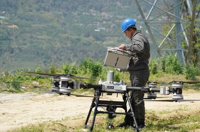 中国重慶の特別高圧直流送電プロジェクト ドローンが長江跨ぎ架設作業