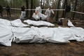 ウクライナ・イジューム近郊の森で見つかった遺体を搬送する科学捜査班（2022年9月16日撮影）。(c)SERGEY BOBOK / AFP