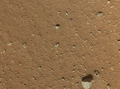 米航空宇宙局（NASA）の火星探査車キュリオシティー（Curiosity）は火星時間の探査33日目（Sol 33）に当たる9月8日、火星拡大鏡撮像装置（MAHLI）が防塵（じん）カバーを外した状態での撮影を行った。

写真は同日、キュリオシティーのアーム部分に取り付けられたMAHLIが着陸後初めて防塵カバーを外して撮影した画像。この画像の鮮明さから、以前MAHLIが撮影した画像の画質が悪かったのはカバーに付いた土ぼこりが原因だったことが確認された。約86センチ四方の範囲の地表を写したもので、画像下部に見える一番大きな石の大きさは約8センチ（2012年9月8日撮影）。(c)AFP/NASA/JPL-Caltech/Malin Space Science Systems