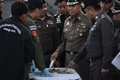 タイの首都バンコク中心部の高架鉄道BTSのサパーンタクシン駅近くで発生した爆発事件の現場で収集された金属片を調べる警察官ら（2015年8月18日撮影）。(c)AFP/Christophe ARCHAMBAULT