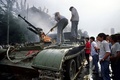 1989年の天安門事件当日、中国・北京の天安門広場付近で軍と衝突した暴徒が火を付けた装甲兵員輸送車を確認する人々（1989年6月4日撮影）。(c) Tommy ChENG / AFP