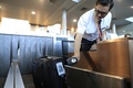 電源不要型電子手荷物タグをスキャンする職員（2019年7月30日撮影）。(c)CNS/殷立勤