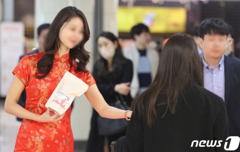 27日午後、韓国空港公社の関係者らが金浦空港で金浦―北京・上海路線の運航再開を記念して入国する乗客に記念品を配っている（共同取材）(c)news1