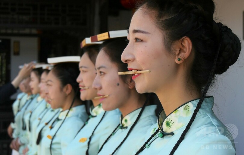 頭上に本、口に箸、手にはトランプ…中国観光ガイドのマナー講習