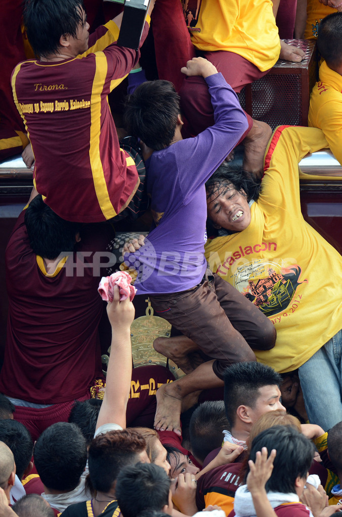 必死、黒いキリスト像に信者が殺到 マニラ