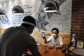 インド・ニューデリー郊外グルガオンのCoCo壱番屋で、スマートフォンを見せて料理を注文する客（右、2020年8月26日撮影）。(c)SAJJAD  HUSSAIN / AFP