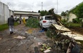 コートジボワールのアビジャンで、車の残骸のそばを歩く人々（2018年6月19日撮影）。(c)AFP PHOTO / Sia KAMBOU