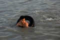 イラク南部バスラで、暑さをしのぐために川で泳ぐ人（2021年7月2日撮影）。(c)Hussein FALEH / AFP