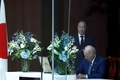 安倍晋三元首相の死去を受け、米首都ワシントンの日本大使公邸を訪れ、冨田浩司大使が見守る中、弔問者芳名録に記帳するジョー・バイデン大統領（2022年7月8日撮影）。(c)SAMUEL CORUM / AFP