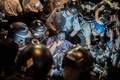 香港（Hong Kong）の旺角（Mongkok）で、催涙スプレーを噴射されたデモ参加者の顔を水で洗う警察官たち（2014年10月17日撮影）。(c)AFP/ANTHONY WALLACE