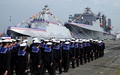 台湾南部・高雄の左営海軍基地で行われた軍艦2隻の就役式で、ミサイル艇「沱江」（左）の前を行進する兵士たち（2015年3月31日撮影）。(c)AFP/Sam Yeh