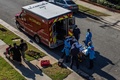 米カリフォルニア州ロサンゼルス郡で新型コロナウイルス感染症の疑いがある患者を救急車両に乗せる救急隊員（2020年12月29日撮影）。(c)Apu GOMES / AFP